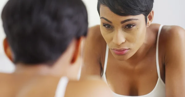 Black woman splashing face with water and looking in mirror — Stock Photo, Image