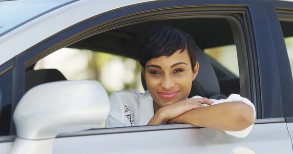 Femme noire souriant et regardant par la fenêtre de la voiture — Photo