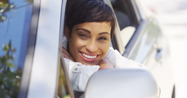 Mulher africana sorrindo e olhando para fora da janela do carro — Fotografia de Stock