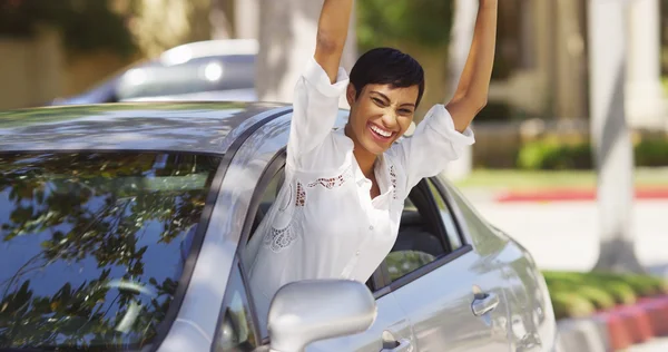 Heureuse femme noire penchée par la fenêtre de la voiture avec les mains en l'air — Photo