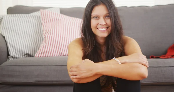 Cute woman sitting in living room laughing and smiling