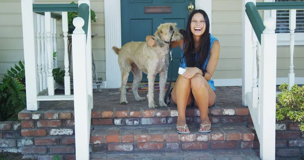 Mujer joven sentada en el porche con su perro — Foto de Stock