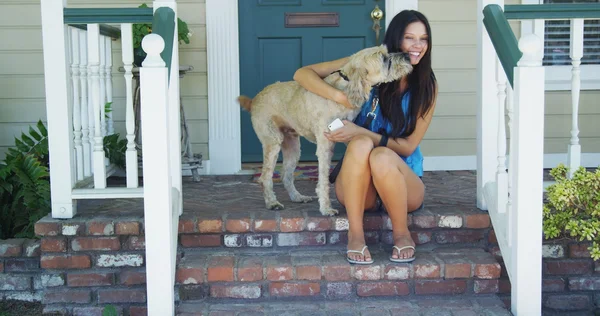 Mujer joven sentada en el porche con su perro — Foto de Stock