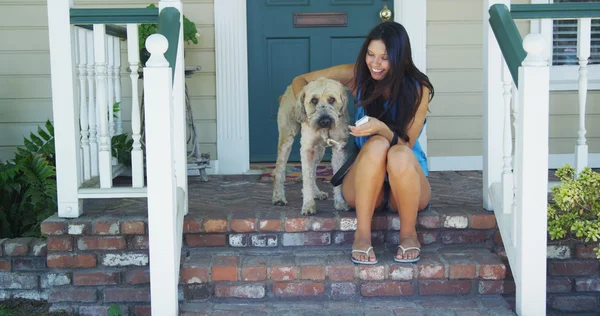 Mujer joven sentada en el porche con su perro — Foto de Stock