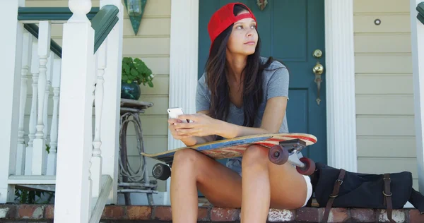 Skatergirl seduto sul portico sms — Foto Stock