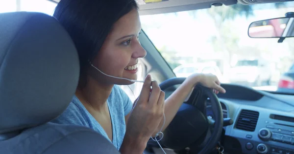 Mulher hispânica falando no carro com fones de ouvido — Fotografia de Stock