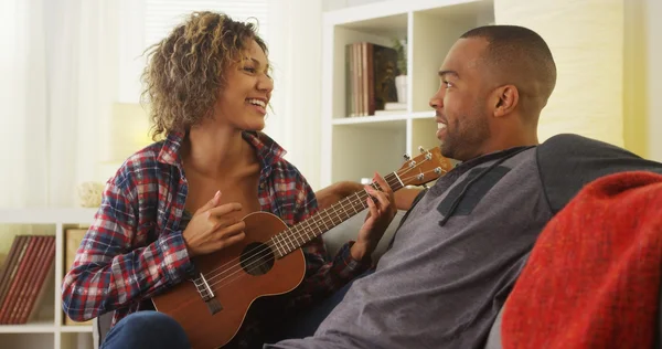 Bonito preto namorada serenata ela namorado com ukulele — Fotografia de Stock