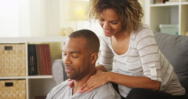 Black girlfriend giving boyfriend massage — Stock Photo, Image