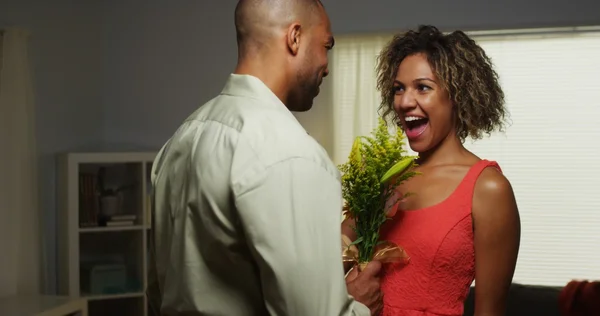 Preto namorado surpreende namorada com flores — Fotografia de Stock