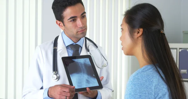 Мексиканский врач говорит с китайским пациентом о рентгене — стоковое фото
