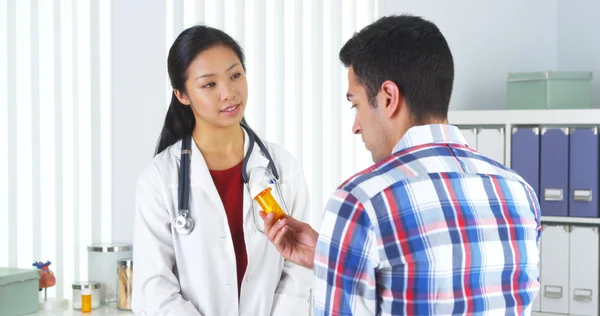 Chinese doctor prescribing medication to patient — Stock Photo, Image