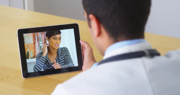 Латиноамериканського лікар говорити з молодої жінки пацієнта планшетний ПК — стокове фото