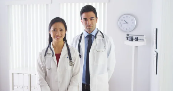 Счастливые врачи, стоящие в офисе — стоковое фото