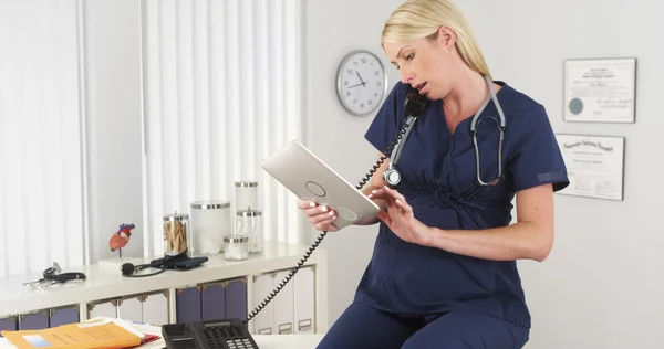 Infirmière enceinte travaillant au bureau — Photo