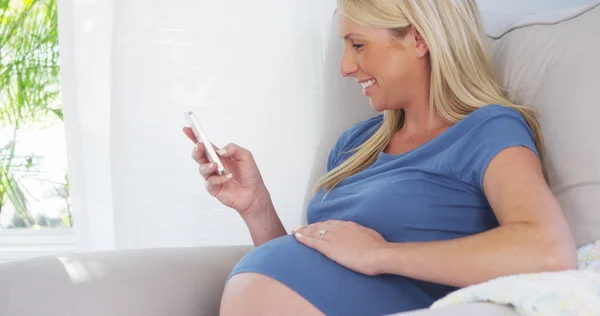 Vackra gravid kvinna textning på smartphone — Stockfoto