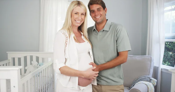 Couple enceinte mignon debout dans la pépinière — Photo