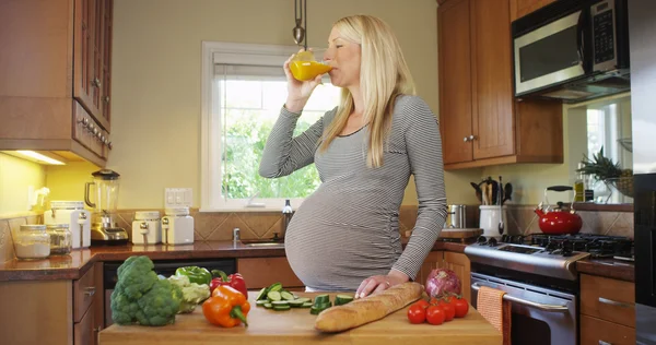 ジュースを飲んで幸せな妊娠中の女性 — ストック写真