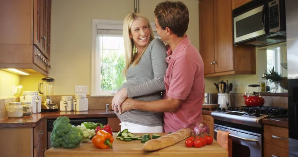 Lyckliga gravida par i köket — Stockfoto
