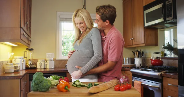 Счастливая беременная пара на кухне — стоковое фото