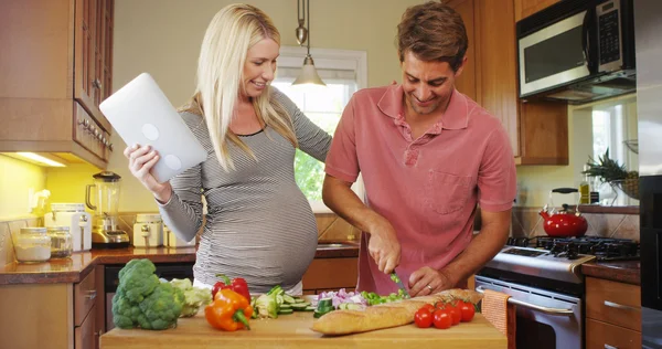 台所で料理をかわいい妊娠中のカップル — ストック写真