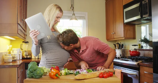 Симпатична вагітна пара готує на кухні — стокове фото