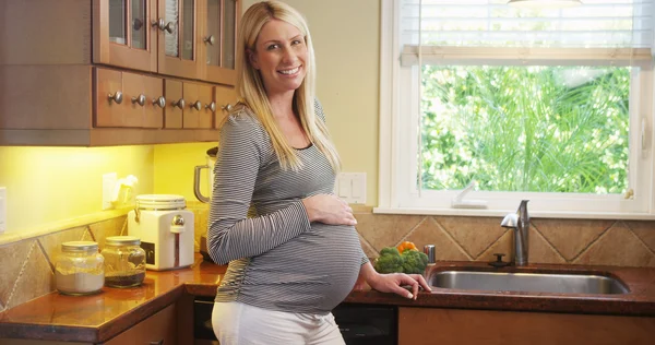 Schöne schwangere Frau steht in der Küche — Stockfoto