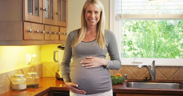 Bella donna incinta in piedi in cucina — Foto Stock