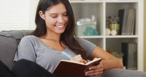 Gemengd ras vrouw zittend op de Bank in het logboek schrijven — Stockfoto