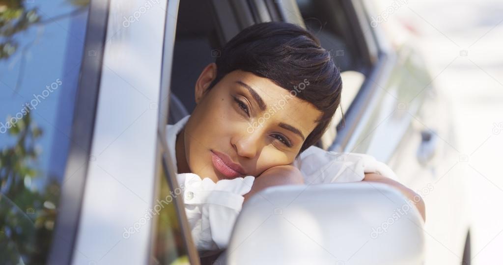 Black woman resting head out car window