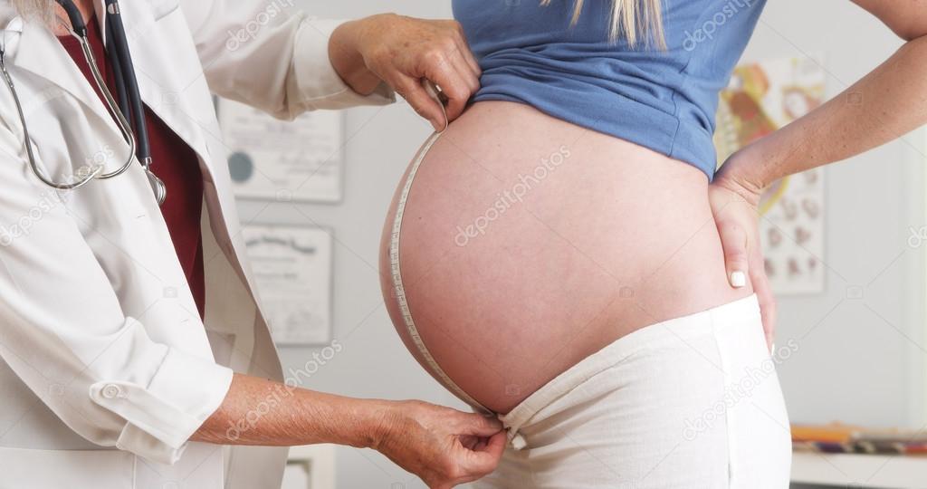 Doctor measuring pregnant woman's belly