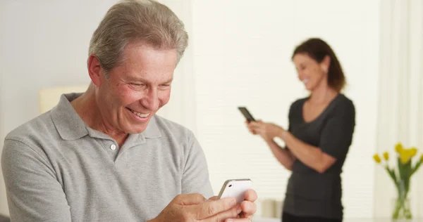 Lycklig senior man använder smartphone — Stockfoto