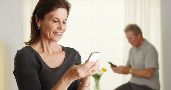 Glückliche Seniorin nutzt Smartphone — Stockfoto
