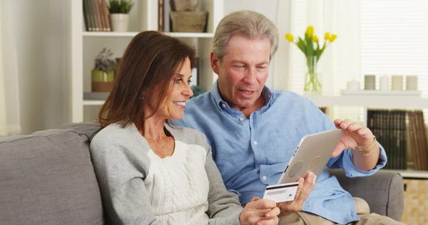 Äldre par med Tablet PC för att göra ett köp — Stockfoto
