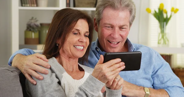 Glückliches reifes Paar nutzt gemeinsam Smartphone — Stockfoto