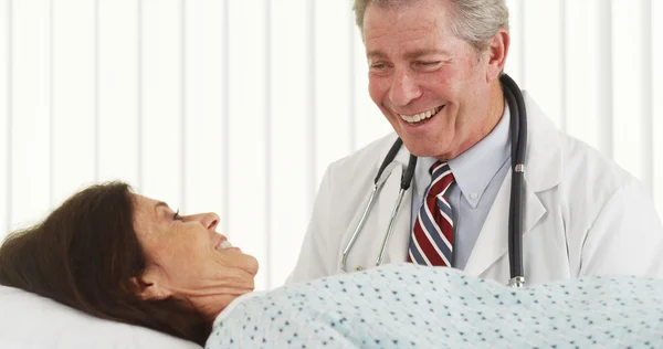 Старший лікар розмовляє і робить посмішку пацієнта — стокове фото