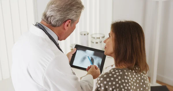 Médecin parlant de rayons X à une patiente âgée — Photo
