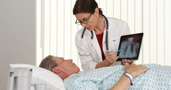 Médecin femme âgée parlant à une patiente âgée couchée au lit — Photo