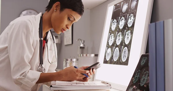 Jovem atraente médico texting resultados de varreduras cerebrais — Fotografia de Stock