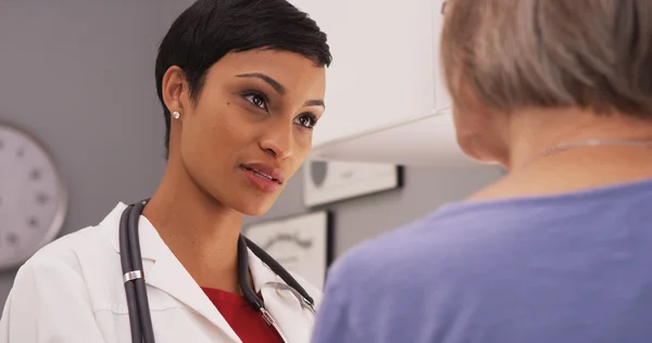 Mladý inteligentní ženský lékař mluví starší pacient — Stock fotografie