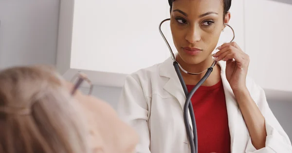 Beautiful female doctor listening with stethoscope — Stock Photo, Image