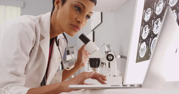 Female technician looking in a microscopec — Stock Photo, Image