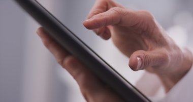 Yaşlı kadın eli bir tablete yazma