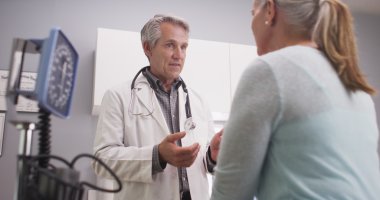 Orta yaşlı doktor Bayan hasta için konuşuyor