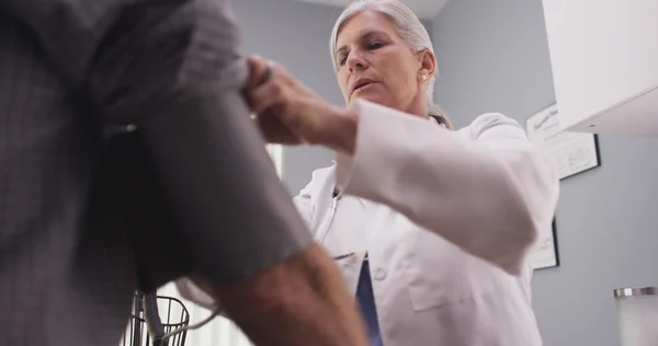 Médecin professionnel mesurant la pression artérielle d'un homme âgé — Photo