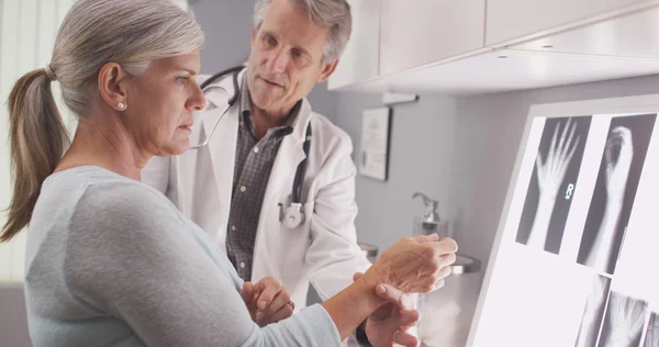 Médecin masculin principal évaluant la fracture du poignet du patient — Photo