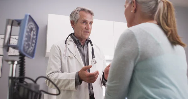 Médico de meia idade conversando com paciente do sexo feminino — Fotografia de Stock