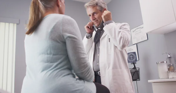 Médecin chevronné écoutant les signes vitaux du patient avec stéthoscope — Photo