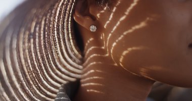 Extreme close up of Black woman with sunhat and diamond earing clipart