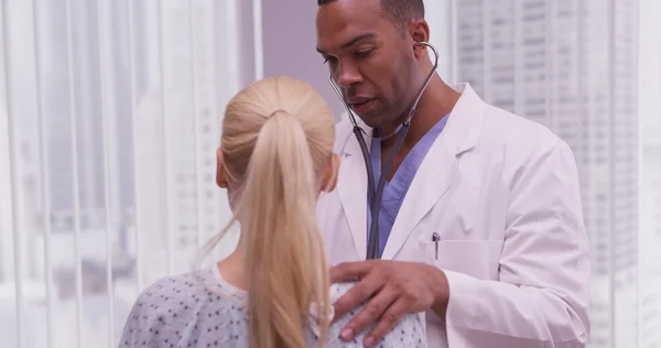 Médico negro escuchando el corazón del paciente —  Fotos de Stock