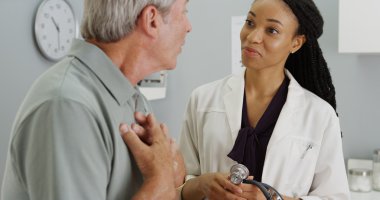 Siyah kadın doktor yaşlı hasta nefes alışını dinliyorum